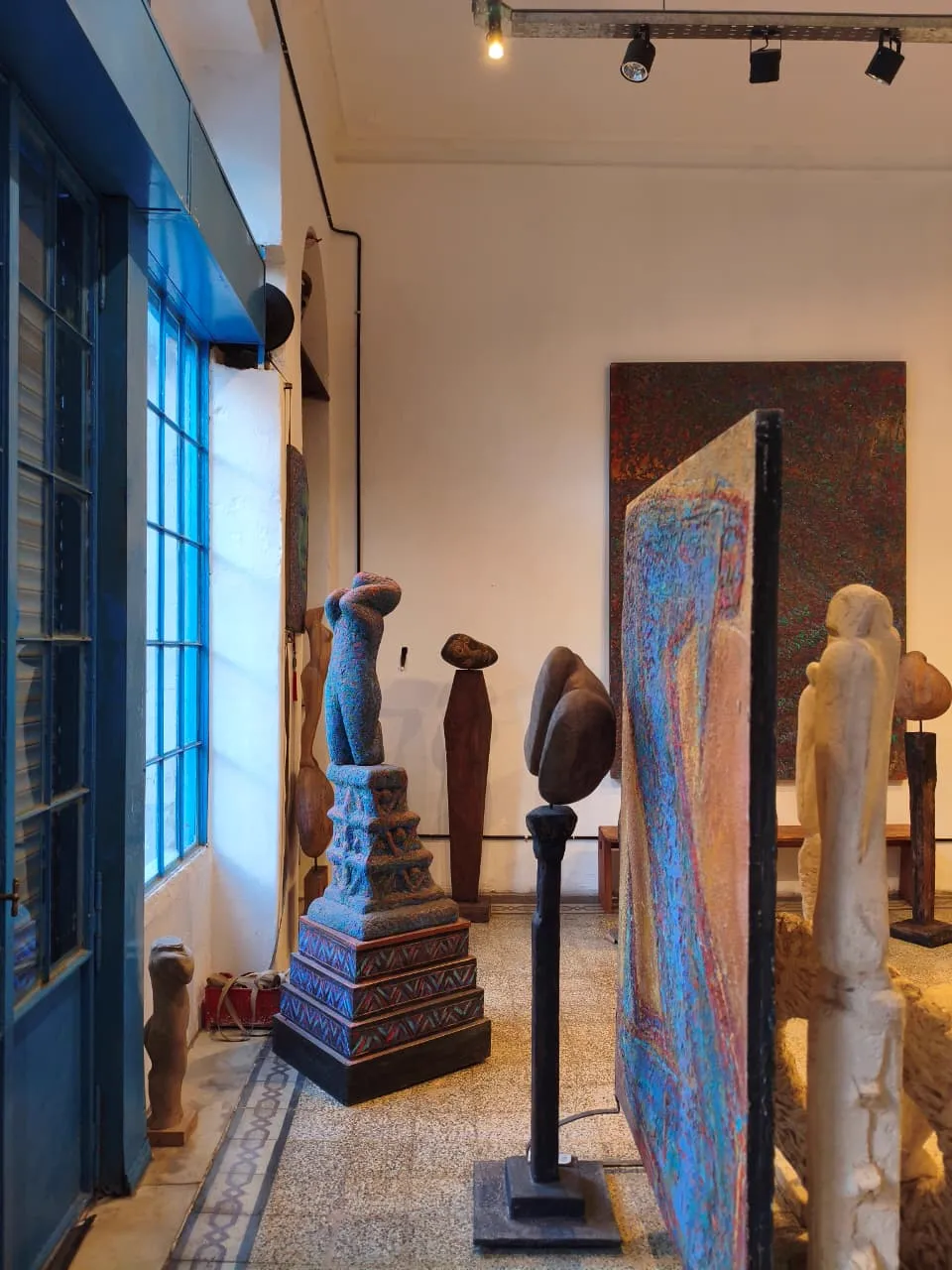 Esculturas precolombinas y assemblages en madera expuestos en la galería.
